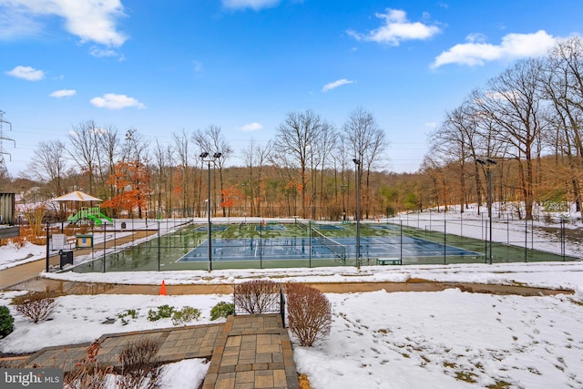 yard covered in snow with a playground and tennis court