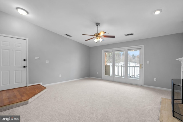 carpeted living room with a multi sided fireplace and ceiling fan