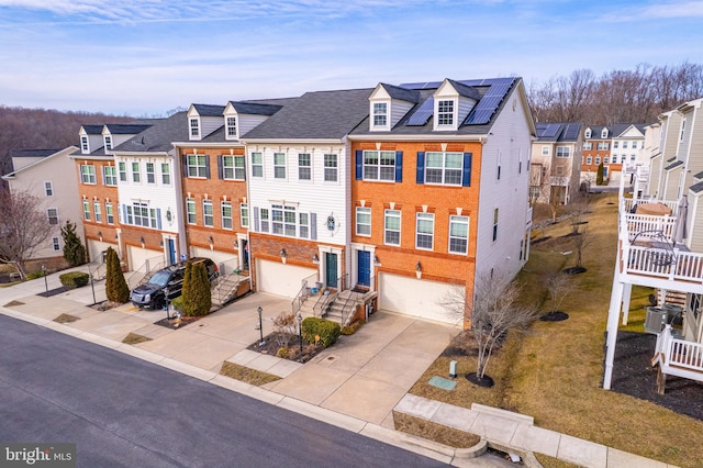 multi unit property featuring solar panels, cooling unit, and a garage