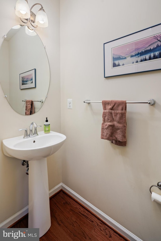 bathroom with a chandelier and wood-type flooring