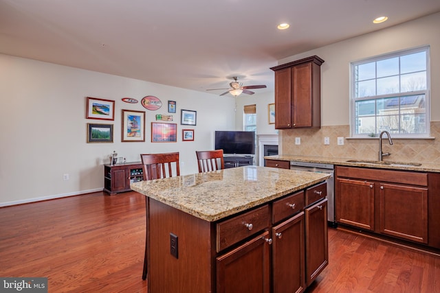 kitchen featuring sink, dishwasher, a kitchen island, dark hardwood / wood-style flooring, and tasteful backsplash