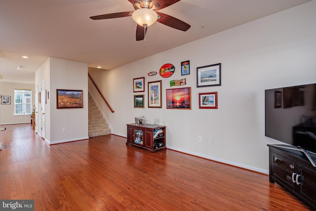 living room with hardwood / wood-style flooring and ceiling fan