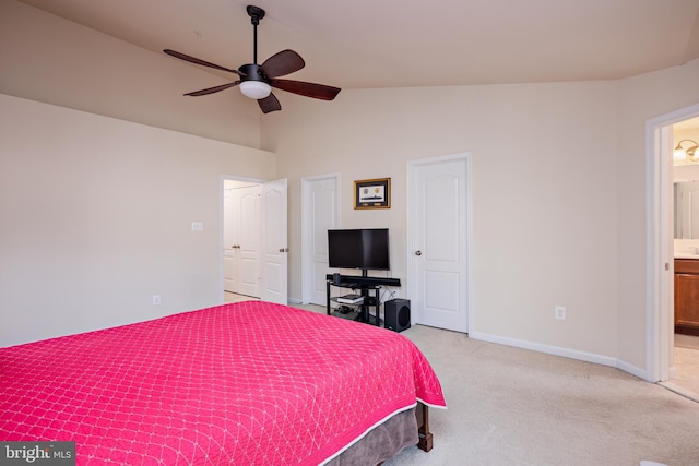 carpeted bedroom featuring vaulted ceiling, connected bathroom, and ceiling fan