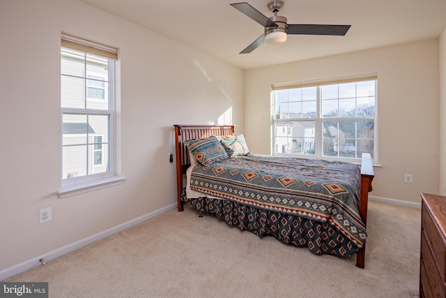 carpeted bedroom featuring multiple windows and ceiling fan