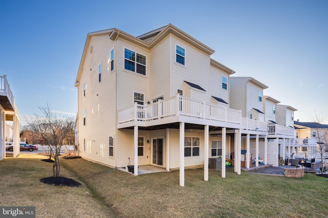 back of property featuring a yard, cooling unit, a patio area, a deck, and an outdoor fire pit