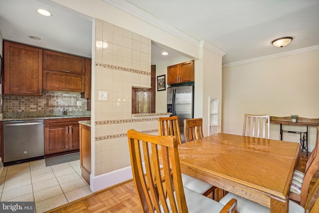 dining space featuring ornamental molding and light tile patterned flooring