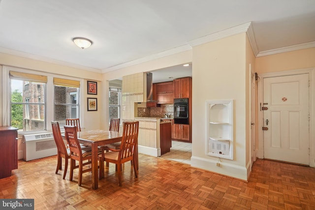 dining space featuring ornamental molding, light parquet flooring, and radiator