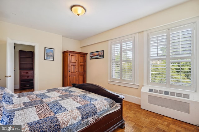 bedroom featuring radiator and light parquet floors