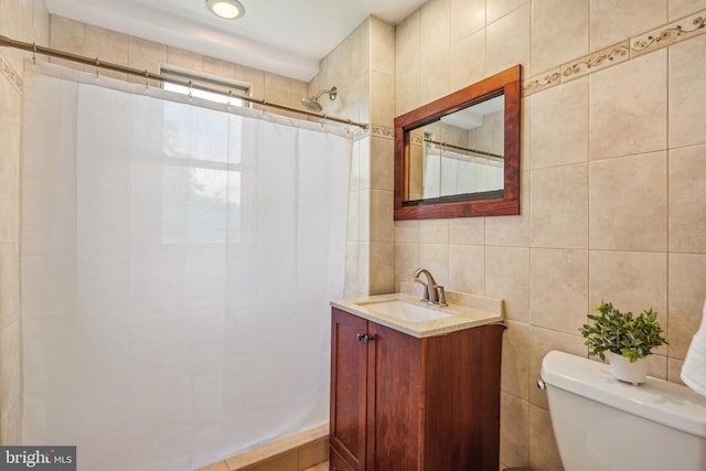 bathroom with vanity, tile walls, a shower with shower curtain, and toilet