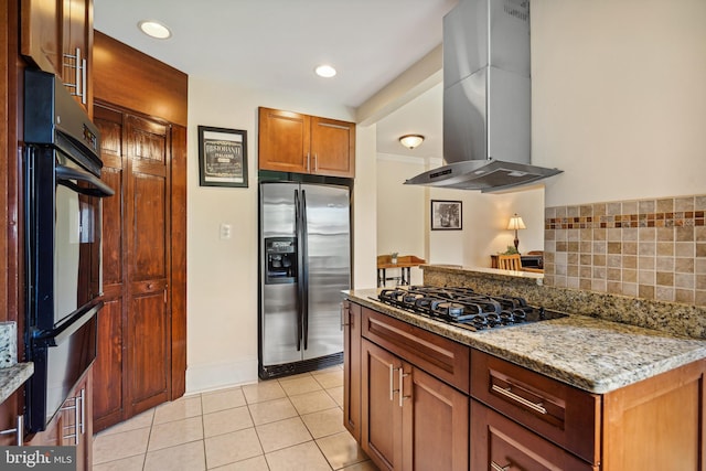 kitchen with island exhaust hood, light stone countertops, light tile patterned floors, and black appliances