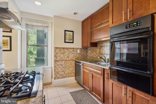 kitchen with light tile patterned floors, gas stovetop, ventilation hood, light stone countertops, and stainless steel dishwasher