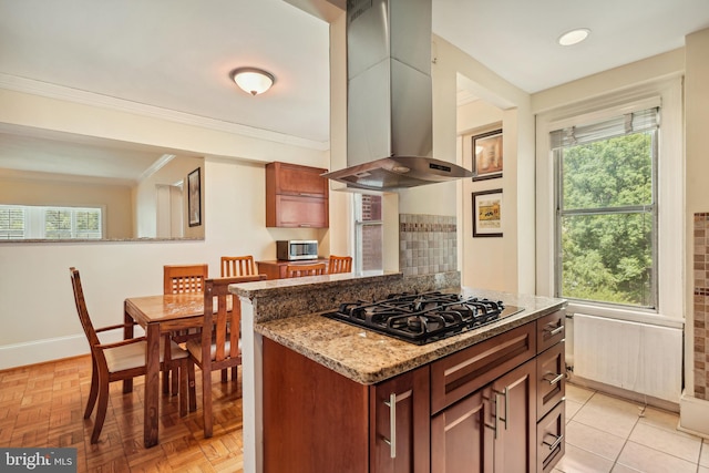 kitchen featuring a healthy amount of sunlight, black gas stovetop, stone counters, and island exhaust hood