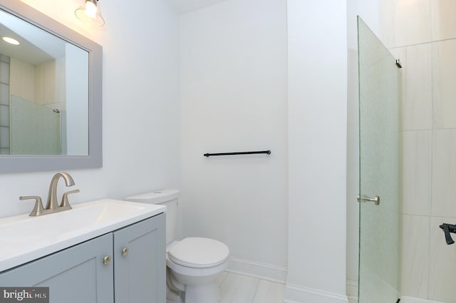 bathroom with vanity, toilet, and a tile shower