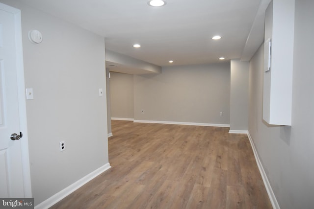 basement featuring light wood-style floors, baseboards, and recessed lighting