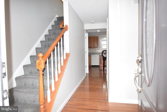 foyer entrance featuring stairs, wood finished floors, visible vents, and baseboards