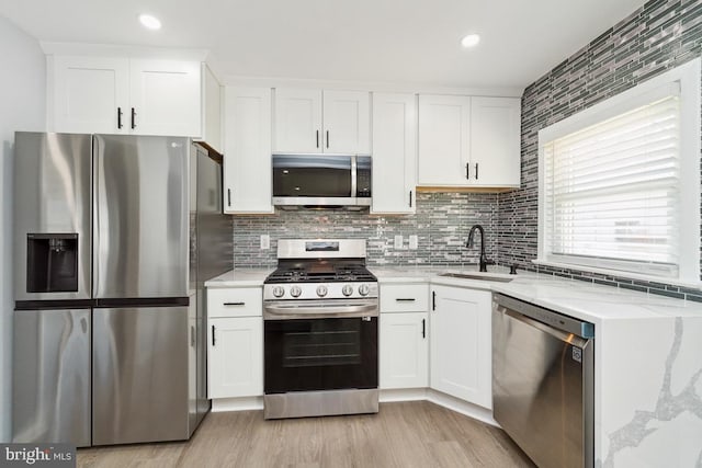 kitchen featuring appliances with stainless steel finishes, sink, and white cabinets