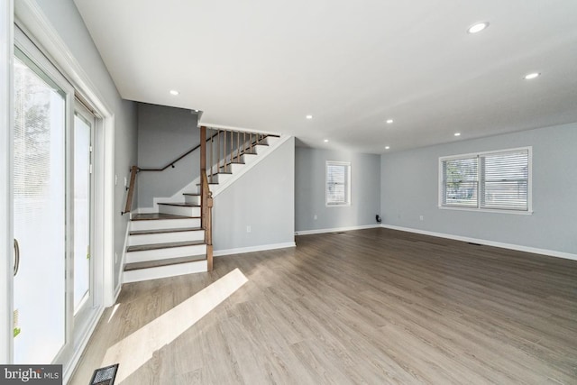 unfurnished living room featuring plenty of natural light and light hardwood / wood-style flooring