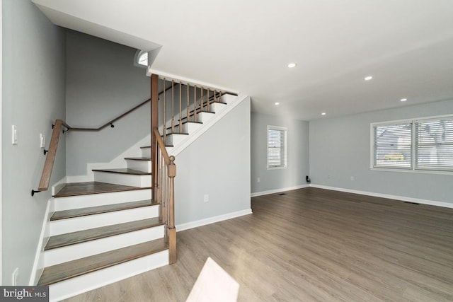 stairway featuring plenty of natural light and hardwood / wood-style floors