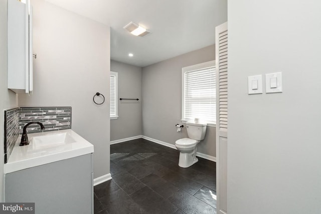 bathroom with tasteful backsplash, vanity, and toilet