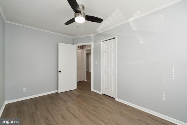 unfurnished bedroom featuring dark hardwood / wood-style flooring, crown molding, a closet, and ceiling fan