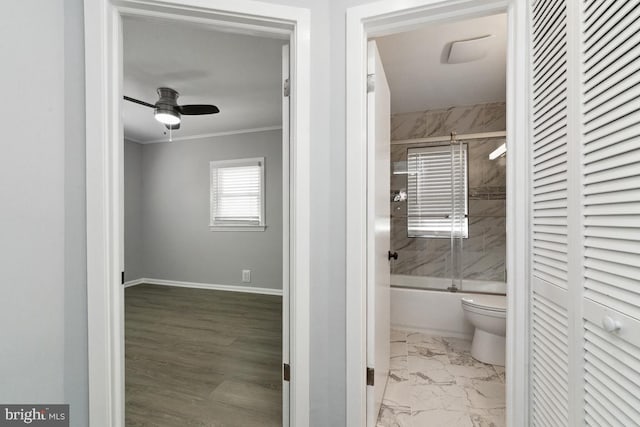 bathroom with ceiling fan, ornamental molding, toilet, and combined bath / shower with glass door