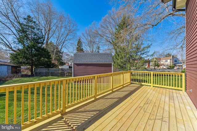 wooden deck featuring a shed and a lawn