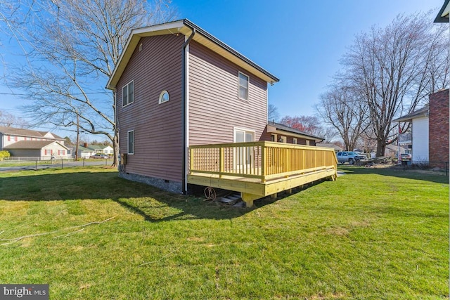 back of house featuring a wooden deck and a yard