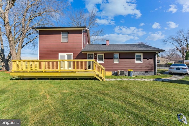 back of house featuring a wooden deck and a lawn