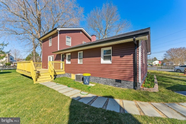 exterior space featuring central AC, a deck, and a lawn