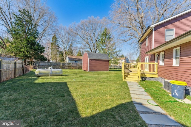 view of yard with a pool side deck and a storage shed