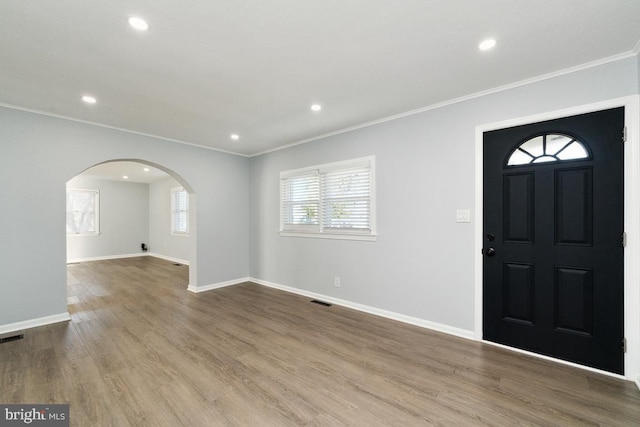 foyer with crown molding and light hardwood / wood-style flooring