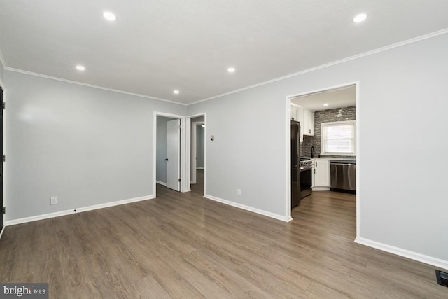 empty room with crown molding and light hardwood / wood-style flooring