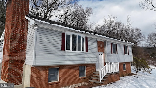 split foyer home with brick siding and a chimney