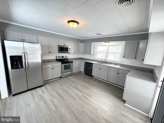 kitchen with sink, gray cabinets, ornamental molding, and appliances with stainless steel finishes