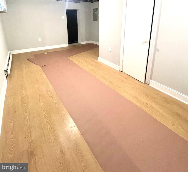 basement featuring wood-type flooring and a baseboard radiator