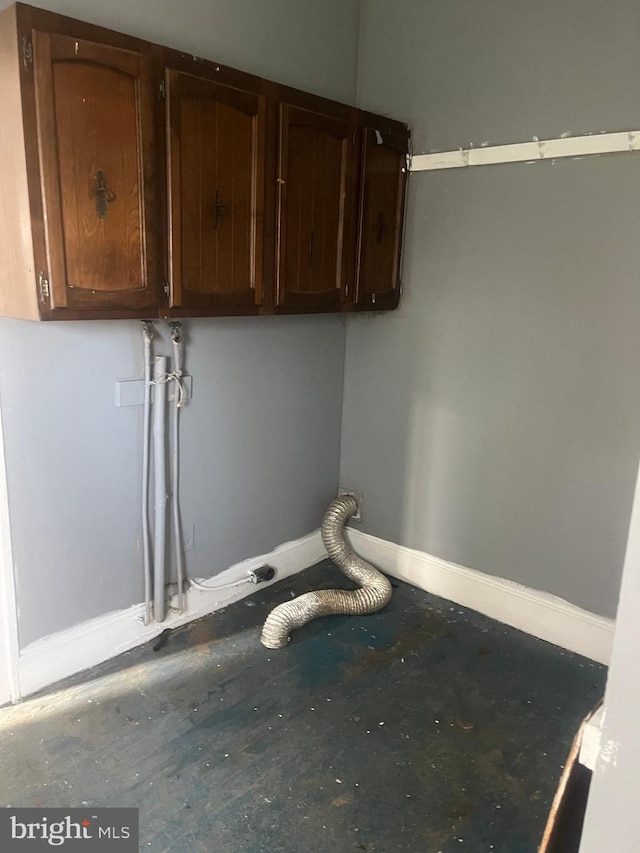 clothes washing area with cabinets