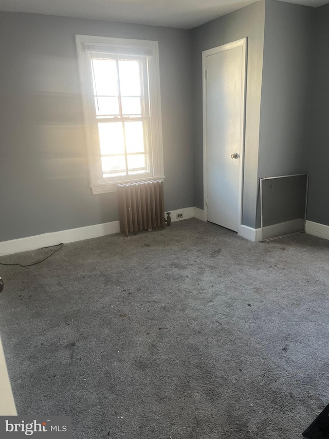 carpeted empty room with radiator