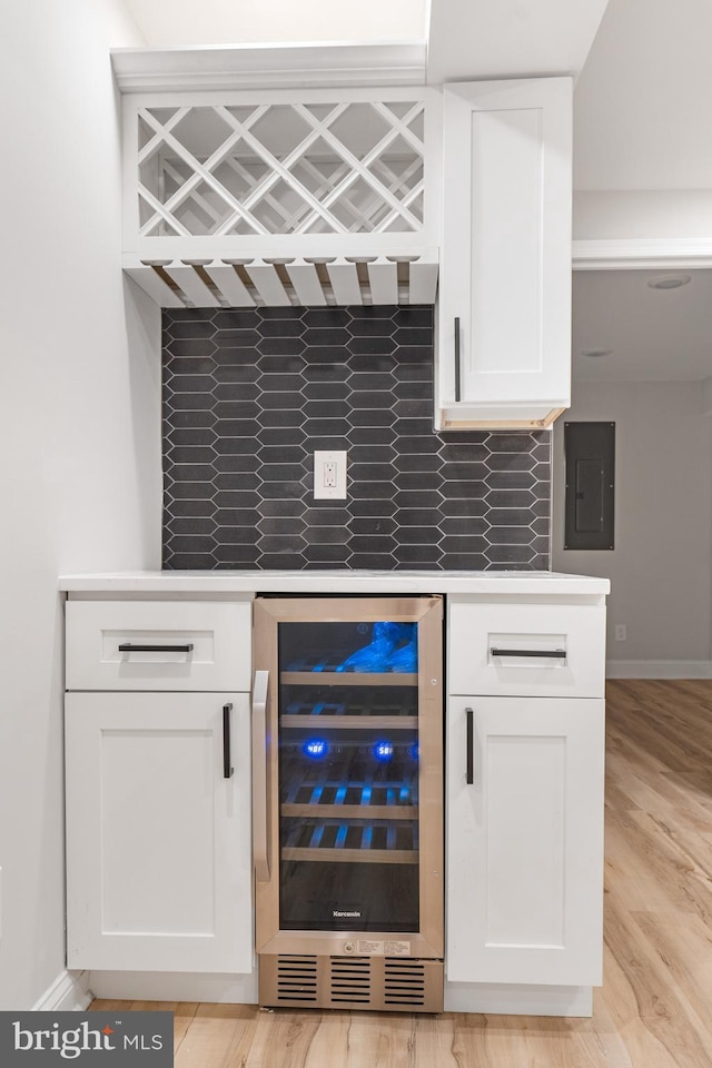 bar featuring white cabinetry, beverage cooler, and electric panel