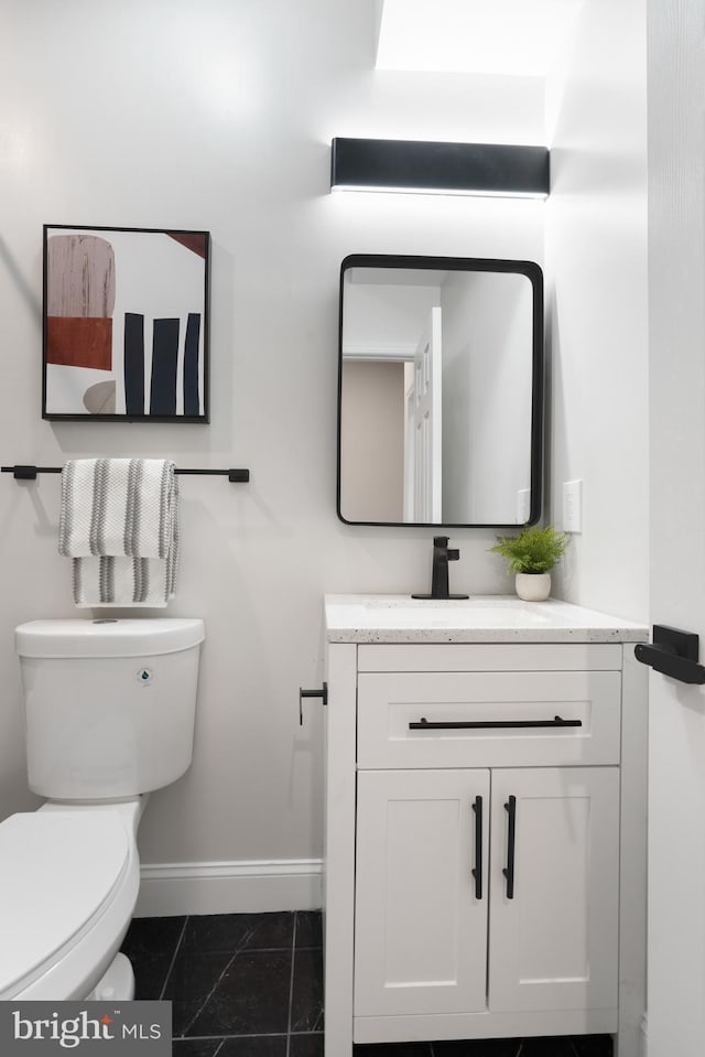 bathroom with tile patterned flooring, vanity, and toilet