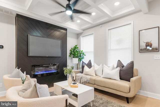 living room with coffered ceiling, ornamental molding, beamed ceiling, a fireplace, and light hardwood / wood-style floors