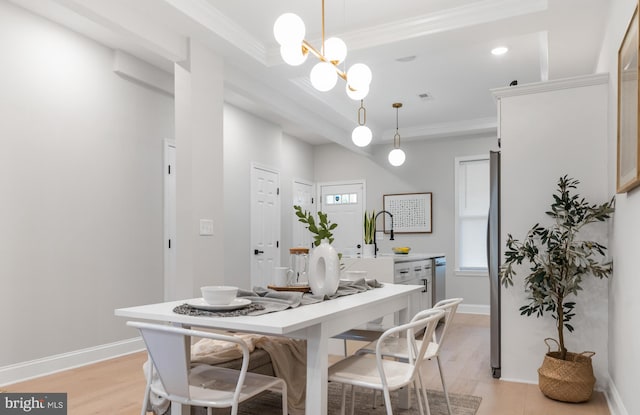 dining area with crown molding, a chandelier, and light wood-type flooring