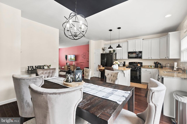 dining space with sink, dark wood-type flooring, and a chandelier