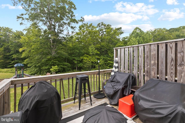 deck featuring area for grilling and a playground