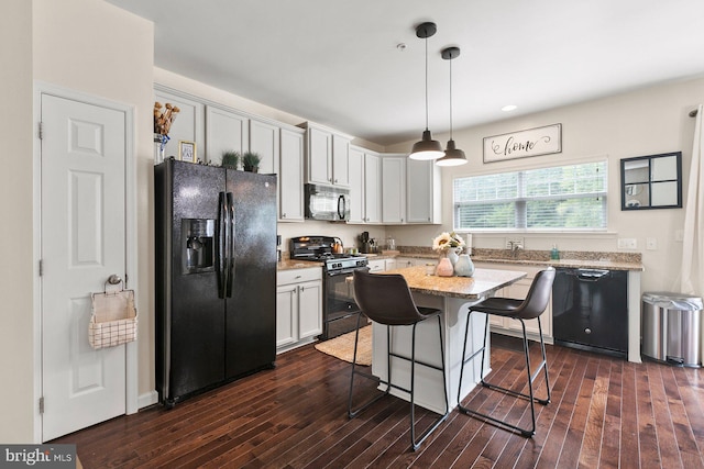 kitchen featuring black appliances, a center island, dark hardwood / wood-style flooring, pendant lighting, and white cabinets