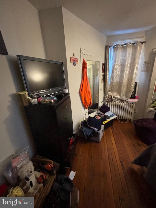 bedroom with hardwood / wood-style flooring and radiator