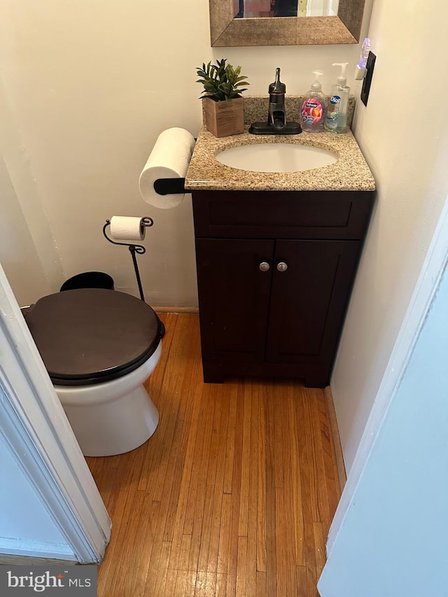 bathroom with hardwood / wood-style flooring, vanity, and toilet