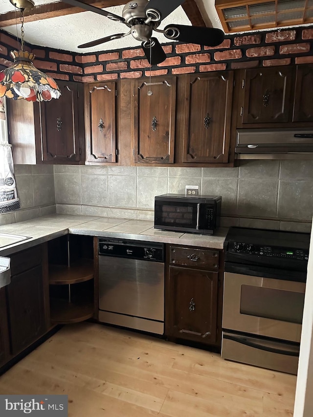 kitchen featuring dark brown cabinetry, light wood-type flooring, ceiling fan, and appliances with stainless steel finishes