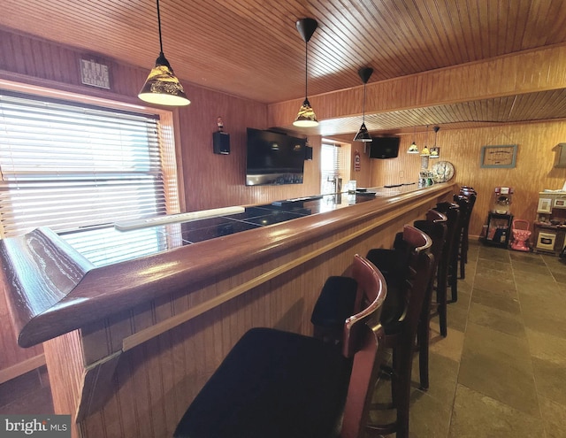 bar featuring wood ceiling, butcher block countertops, hanging light fixtures, and wood walls