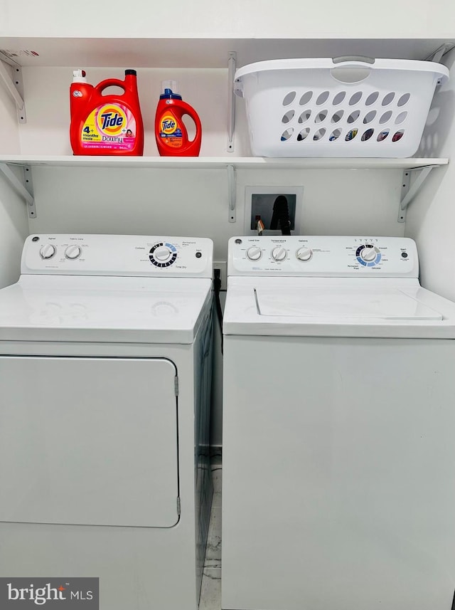 clothes washing area featuring washing machine and dryer and laundry area