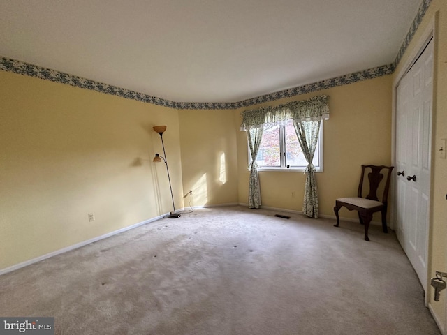 carpeted empty room with visible vents and baseboards